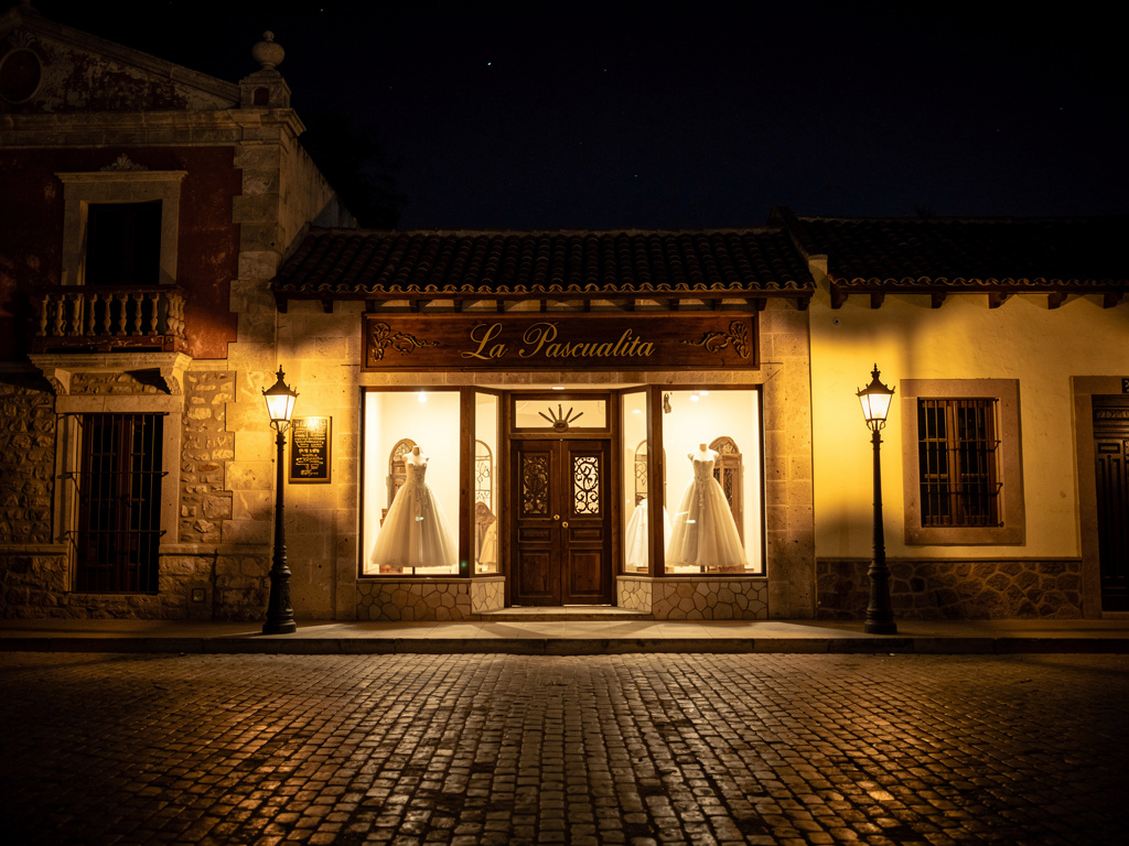 Imagina si: 🕯️ La Pascualita – Guion para cómic
🖼️ Página 1: La leyenda comienza.
Viñeta 1:
Exterior de una tienda de vestido