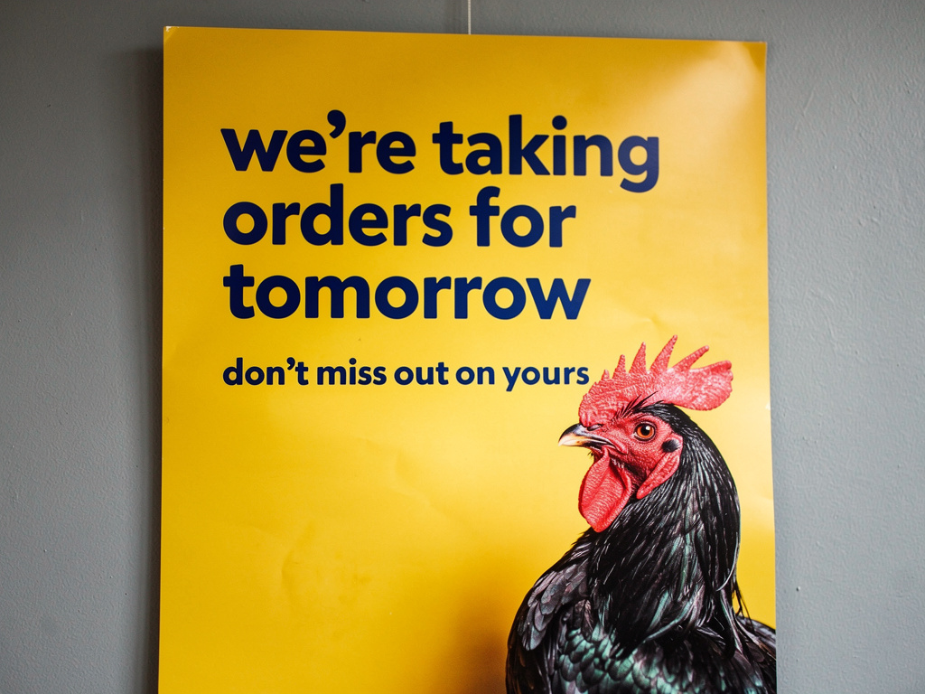 Imagina si: Un afiche que diga estamos anotando pedidos para el día de mañana. No te quedes sin el tuyo y un pollo en una esq
